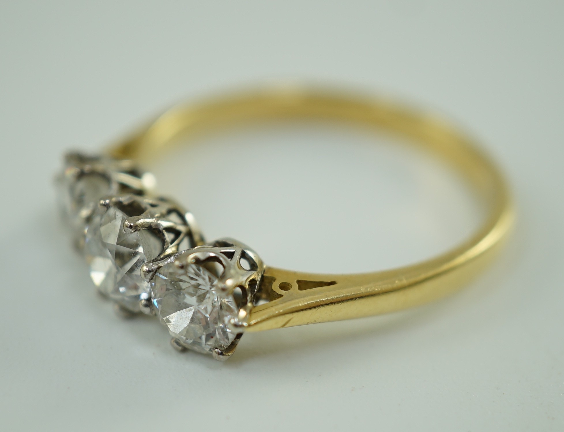 A modern 18ct gold and three stone diamond set ring